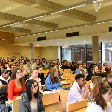 Erstsemester im voll besetzen Hörsaal während der Einführungsveranstaltung